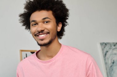 Genç ve yakışıklı bir adam sanatla çevrili şık bir ortamda mutluluk saçar..