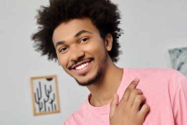 Parlak ve neşeli genç adam, sıcak gülümsemesi ve şık kıyafetiyle dikkatleri üzerine çekiyor..