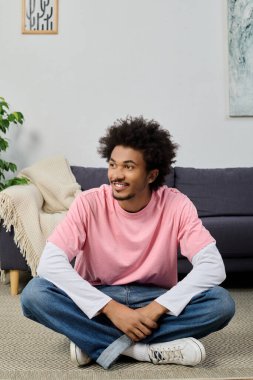 Yakışıklı genç adam şık bir oturma odasında bacak bacak üstüne atmış, sakince gülümsüyor ve rahatlıyor..