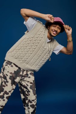 Çekici bir gülümsemesi olan genç adam eşsiz moda anlayışını oyuncu bir gösteride sergiliyor..