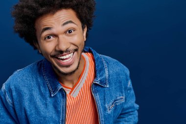 Büyük bir gülümseme ile, yakışıklı genç bir adam neşeli kişiliğini gösterir, günlük kıyafetler giyer..