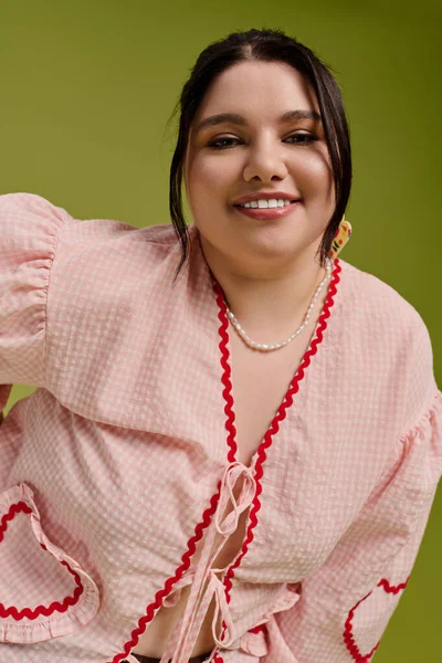 Kendine güveni tam bir maket, moda anlayışını neşeli bir gülümsemeyle, canlı bir ortamda sergiliyor..