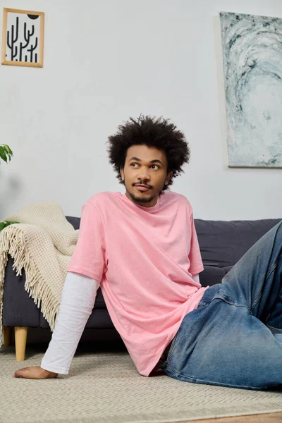 Genç yakışıklı bir adam rahat bir şekilde kanepede uzanıyor, evinde huzurlu bir anın tadını çıkarıyor..