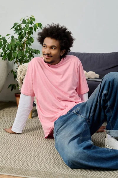 Genç ve yakışıklı bir adam, şık bir ev ortamında huzur içinde yerde dinleniyor..