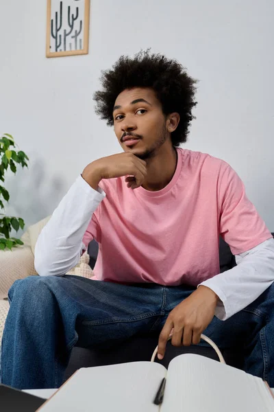 Genç ve yakışıklı bir adam, modern ve davetkar bir mekanda fikirleri düşünerek, çenesini elinin üzerine koyar..