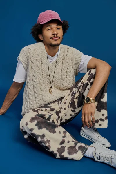 Yakışıklı genç adam şık örgü giysiler ve eşsiz desenli pantolonlar içinde poz veriyor..