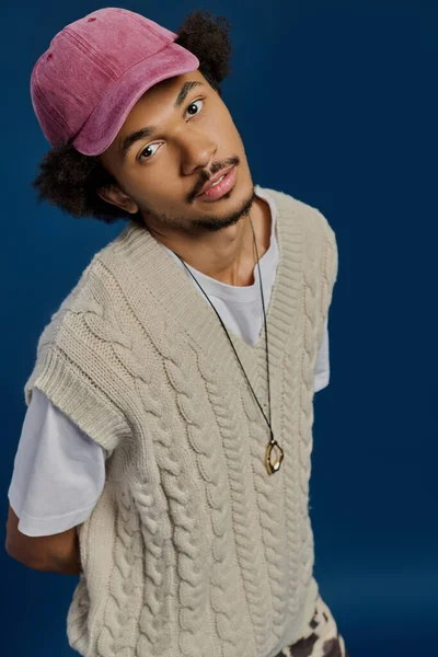 Şık bir genç adam neşeli bir ifadeyle benzersiz moda ve çekiciliğini sergiliyor..