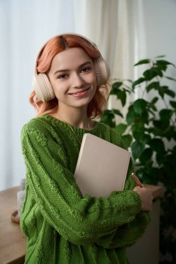 Yeşil kazaklı güzel genç kadın evde yaratıcı bir anın tadını çıkarıyor..