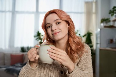 Yeşillik ve yumuşak ışıkla çevrili çay yudumlayan güzel bir kadınla rahatlatıcı bir öğleden sonra sahnesi..