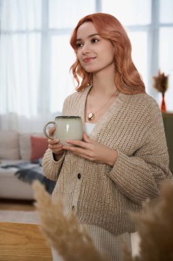 Genç bir kadın, rahat bir ortamda sessiz bir anın tadını çıkarır..