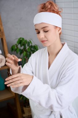 Güzel genç bir kadın huzur dolu bir sağlık ortamında dinlenirken cilt yağı sürüyor..