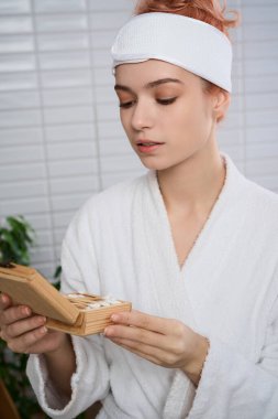 Beyaz cüppeli hoş bir genç kadın cilt bakımı yapıyor..