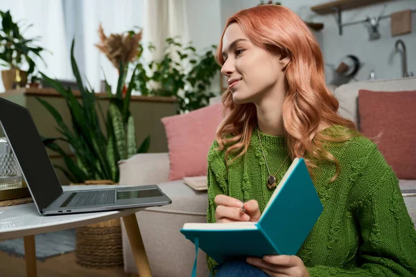 Güzel, genç bir kadın rahat bir oturma odasında oturmuş, defterine gülümserken bir şeyler yazıyor..