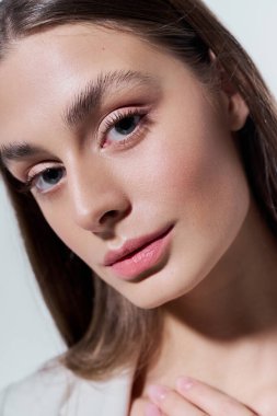 Güzel, genç bir kadın, sakin ve büyüleyici bir ortamda usulca gülümsüyor..