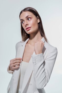 Güzel genç bir kadın sofistike bir stil sergiliyor. Kendine güvenen minimalist bir ortamda..