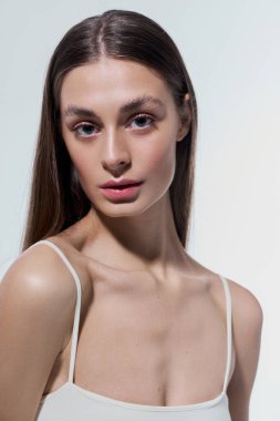 Çekici genç bir kadın zarafetini ve çekiciliğini sakin bir ifadeyle ve pürüzsüz bir tenle sergiliyor..