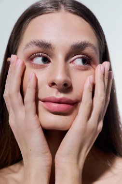 Nazik bir gülümseme ile, güzel bir genç kadın sevgiyle yüzünü tutar, büyüleyici ve zarif bir şekilde..