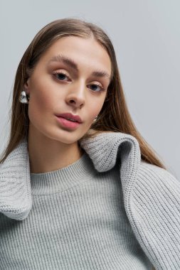 Genç bir kadın tarzını dalgalı saçlarıyla ve zarif aksesuarlarıyla sergiliyor..