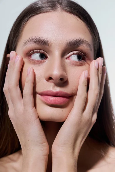 Nazik bir gülümseme ile, güzel bir genç kadın sevgiyle yüzünü tutar, büyüleyici ve zarif bir şekilde..