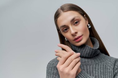 Kendine güvenen genç bir kadın zarifçe poz verir, zarafeti içinden parlar..