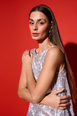 Çekici genç bir bayan, parlak bir elbiseyle özgeçmişinde zarafet sergiliyor..