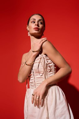 Güzel, genç bir kadın şık bir şekilde poz veriyor, moda anlayışı ve karizmasını sergiliyor..