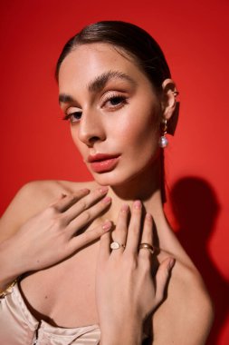 Genç bir kadın zarafetini ve çekiciliğini göz alıcı makyaj ve şık aksesuarlarla sergiliyor..