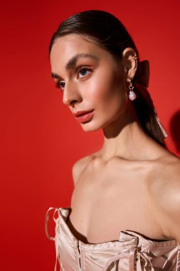 Genç bir kadın kendine güvenerek poz veriyor, sofistike stilini ve kalın rujunu gösteriyor..