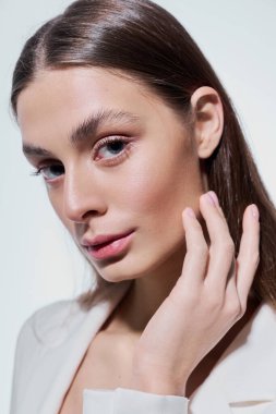 Genç bir kadın alımlı bakışları ve şık duruşuyla zarif yüz hatlarını sergiliyor..