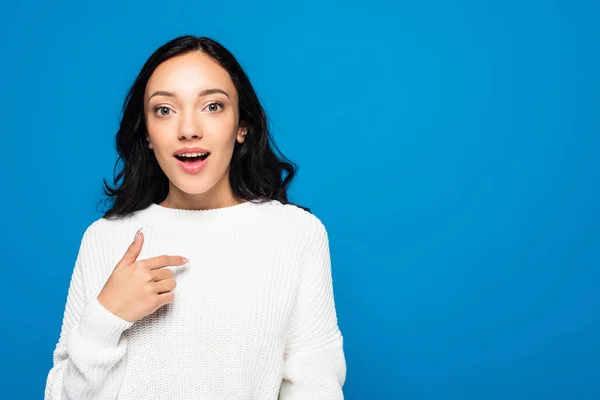 Mujer sorprendida con la boca abierta mirando a la cámara y señalándose a sí misma aislada en azul - foto de stock