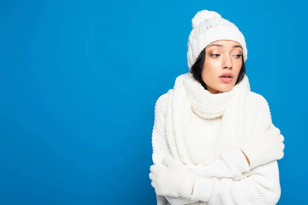 Femme en bonnet tricoté et gants gel isolé sur bleu — Photo de stock