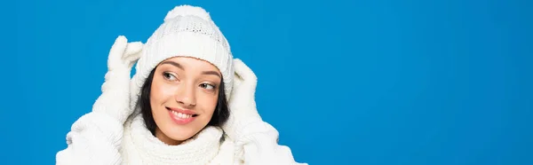 Mulher feliz em roupa de inverno branco olhando para longe isolado em azul, banner — Fotografia de Stock