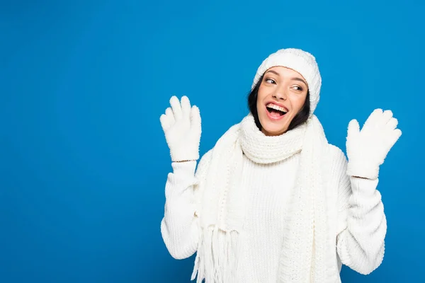 Mulher animado em roupa de inverno branco olhando para longe isolado em azul — Fotografia de Stock