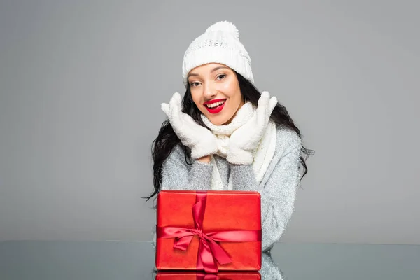 Excited woman in winter outfit near present isolated on grey — Stock Photo