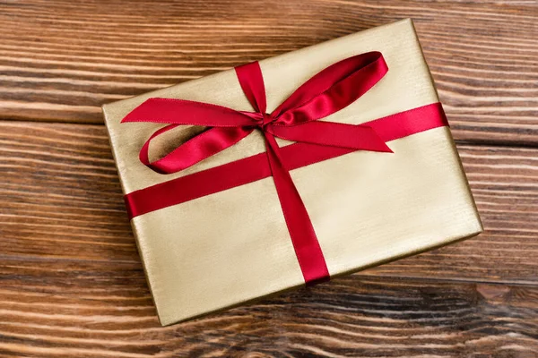 Top view of gift box with red ribbon on wooden background, new year concept — Stock Photo