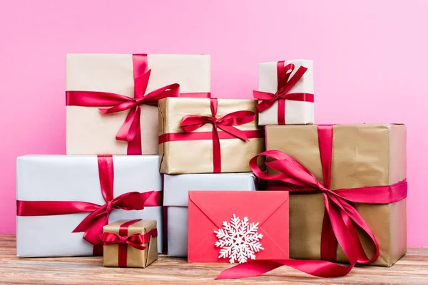Surface level of gift presents, red envelope and decorative snowflake on pink background — Stock Photo