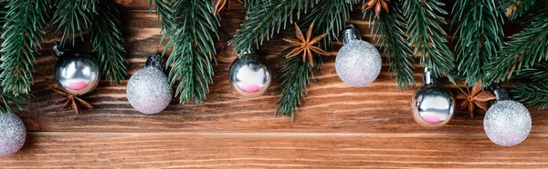 Vista superior de bolas de Natal, ramos de pinho e estrelas de anis no fundo de madeira marrom, banner — Fotografia de Stock