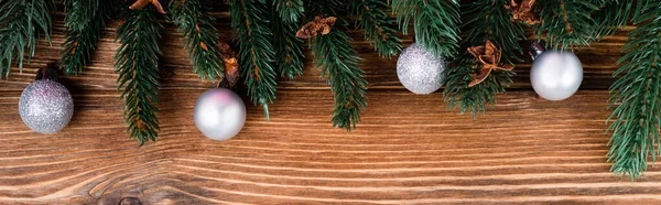 Top view of baubles, anise stars and pine branches on brown wooden background, banner — Stock Photo