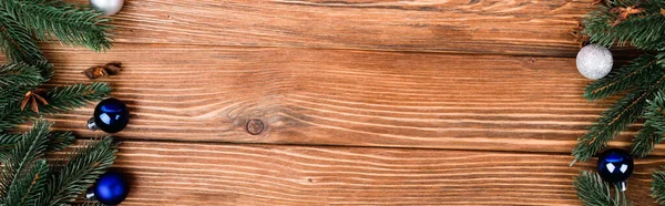 Asiento plano con ramas de pino, bolas de Navidad y estrellas de anís sobre fondo de madera marrón, pancarta - foto de stock