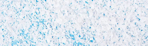 Top view of artificial snow on blue background, new year concept, banner — Stock Photo