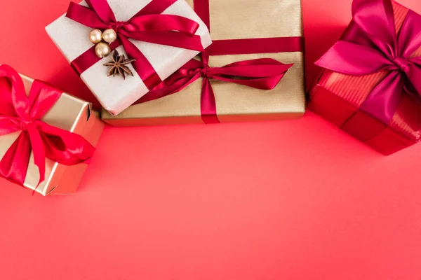 Top view of gift boxes with beads and anise star on red background, new year concept — Stock Photo