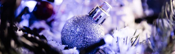 Close up view of christmas ball with pine branch and artificial snow on blurred background, banner — Stock Photo