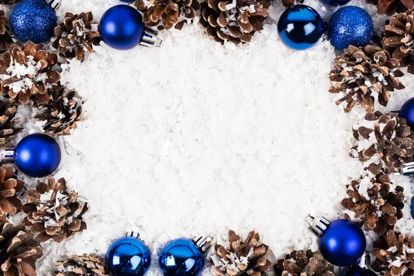 Pose plate avec des cônes de pin et des boules de Noël sur fond texturé blanc — Photo de stock