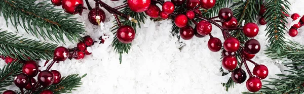 Top view of spruce branches and artificial red berries on white textured background, banner — Stock Photo