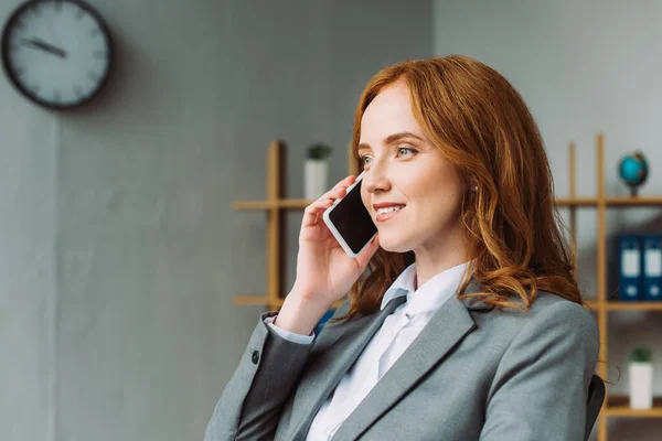 Lächelnde Rechtsanwältin, die am Handy spricht und vor verschwommenem Hintergrund wegsieht — Stockfoto