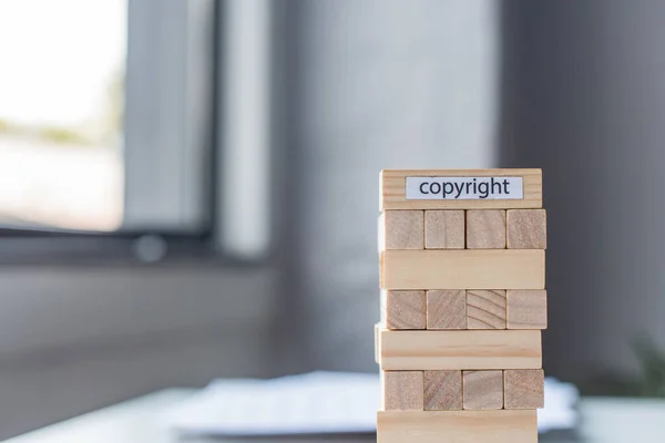 Blocos de madeira torre jogo com letras de direitos autorais sobre fundo borrado — Fotografia de Stock