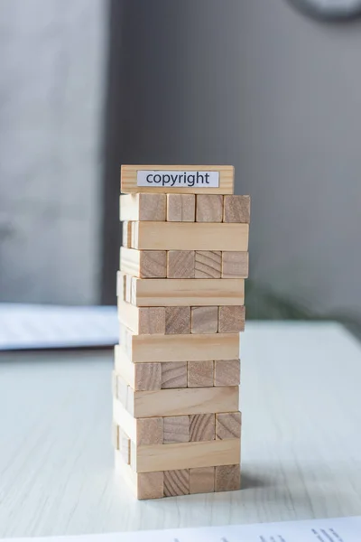 Blocos de madeira torre jogo com letras de direitos autorais sobre fundo borrado — Fotografia de Stock