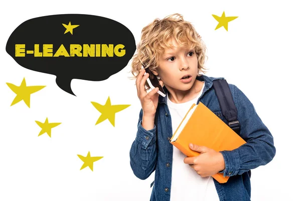Curious schoolboy holding book and talking on smartphone near e-learning lettering in speech bubble illustration on white — Stock Photo
