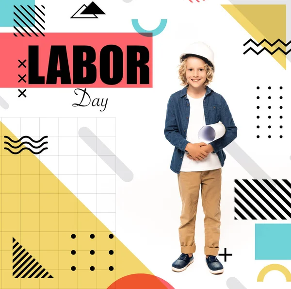 Curly boy in safety helmet and costume of architect holding blueprint near labor day lettering on white — Stock Photo
