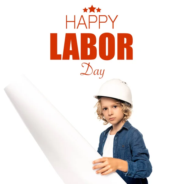 Boy in safety helmet and costume of architect holding blueprint happy labor day lettering on white — Stock Photo